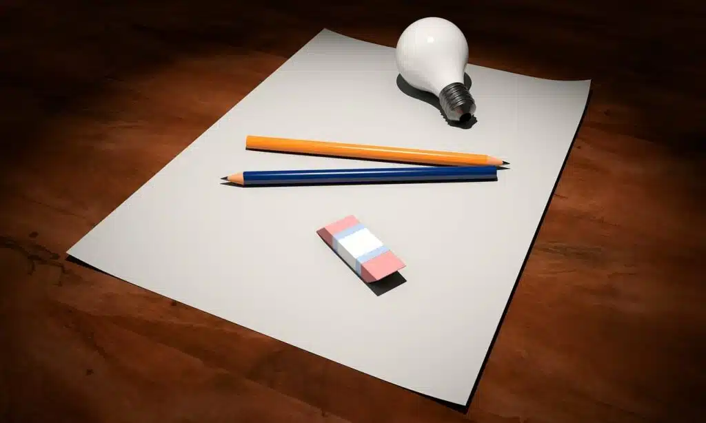 Penna med glödlampa och suddgummi på papper